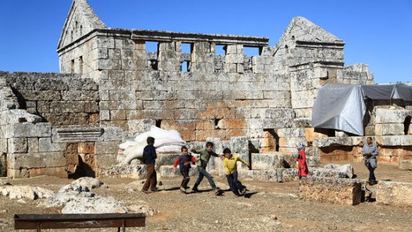 Syrian refugee children play in front of the ruins of the public baths of the ancient Byzantine-Christian city of Serjilla. (Image credit: AFP)