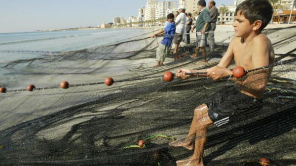 A twelve-year-old boy helps the fisherman in southern Lebanon's port Tyre.  (AFP/Ramzi Haidar)