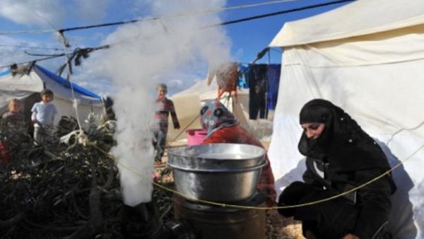سورية تطبخ على الحطب في مخيم قاه/أ.ف.ب