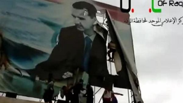 معارضون يمزقون صورة للرئيس السوري في الرقة/أ.ف.ب