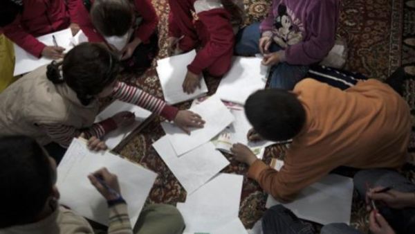 طلبة سوريون شردتهم الحرب يحضرون درسا في مدرسة بديلة بدير الزور/أ.ف.ب