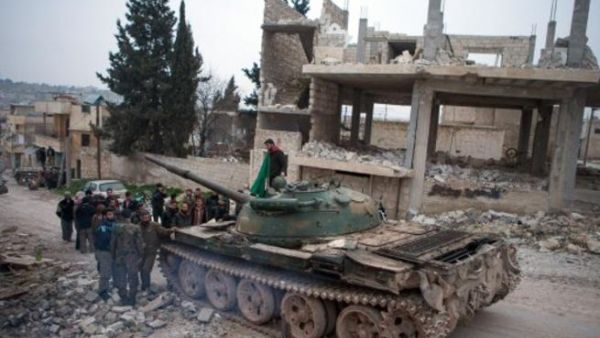 مقاتلون من المعارضة يتجمعون حول دبابة ت 72 غنموها من الجيش النطامي/أ.ف.ب