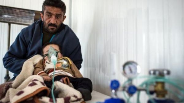 سوري مشرد يصطحب ابنه المريض الى عيادة صحية في مخيم اعزاز/شمال سوريا/أ.ف.ب