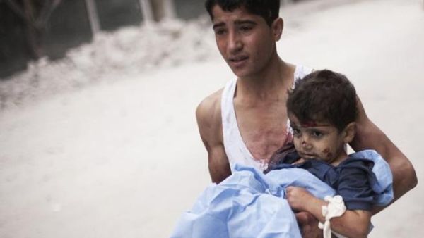 شاب يسعف شقيقه الذي اصيب بقصف القوات النظامية على احد احيار حلب