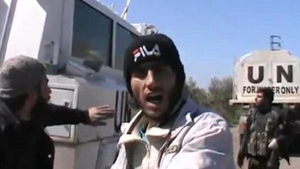 مسلحون يقفون بجانب شاحنات قوات الامم المختطفة/أ.ف.ب