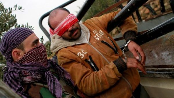 مقاتل من المعارضة يعتقل شخصا مجهول/ا.ف.ب