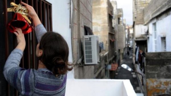 دمشقية تزين منزلها بزينة الميلاد/أ.ف.ب