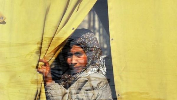 سورية تنظر من نافذة حافلة وهي مغادرة حلب/أ.ف.ب