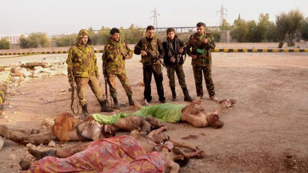 جنود من الجيش النظامي يقفون امام جثث مقاتلين من المعارضة بالقرب من حلب/أ.ف.ب
