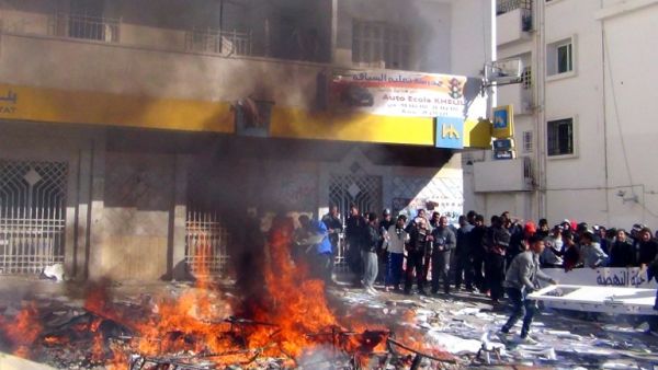 Tunisians protestors set fire to documents and belongings of the country's ruling Islamist Ennahda party's outside their headquarters in the central Tunisian town of Gafsa on November 27, 2013. [AFP]