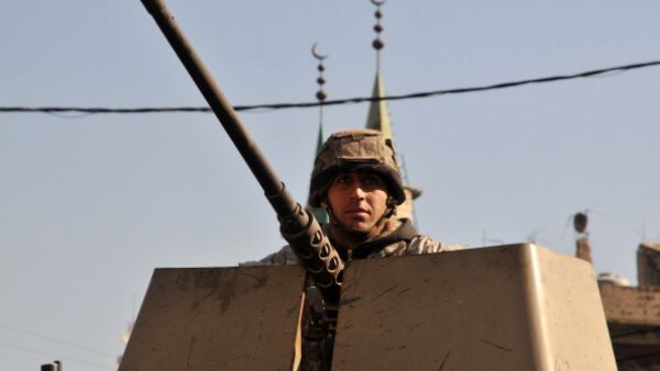 A Lebanese army soldier patrols a street with an armoured vehicle in the northern Lebanese city of Tripoli on October 29, 2013. [IBRAHIM CHALHOUB/Getty Images]