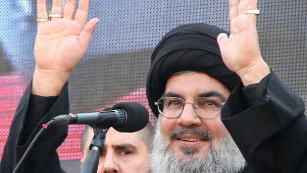 The head of Lebanon's militant Shiite Muslim movement Hezbollah, Hassan Nasrallah greets the audience after speaking during a massive Shiite Muslim commemoration in southern Beirut on November 14, 2013. [Getty Images]