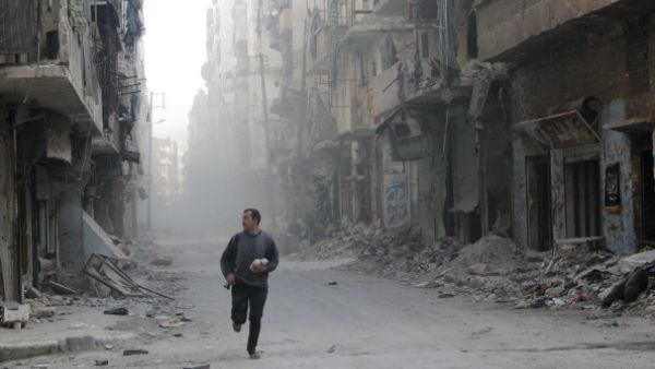 A rebel fighter from the Free Syrian Army runs in a street of Aleppo's Salah al-Din neighbourhood during fighting against Syrian government forces on November 18, 2013. [AFP]