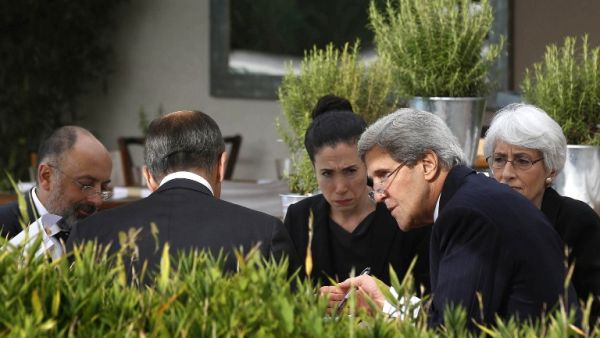 US Secretary of State John Kerry and Russian Foreign Minister Sergei Lavrov (back to camera) meet while seated with their senior aides at a hotel in Geneva on September 14, 2013.  [AFP]