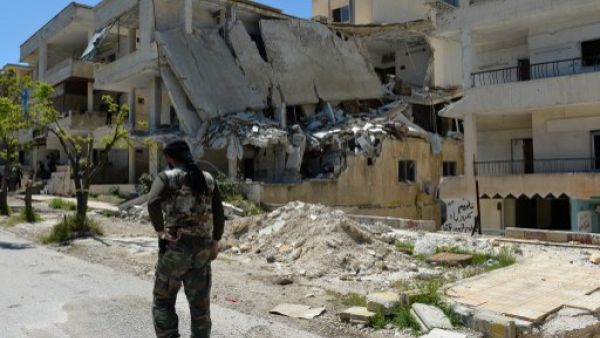 مقاتل من المعارضة يمشي وسط دمار في منطقة سملى في محافظة اللاذقية/ا.ف.ب