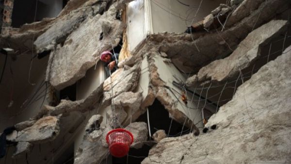 سوري ينقل بسلة بلاستيكية اغراضا من بيته المدمر بفعل القصف الجوي في حلب/أ.ف.ب