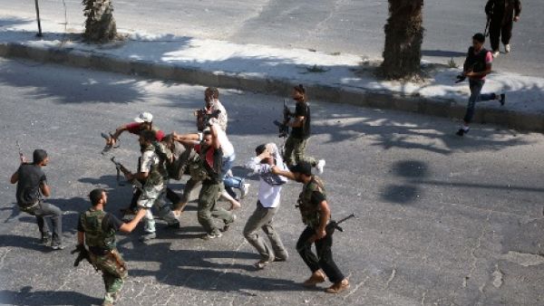 Rebel Free Syrian Army fighters drag a man suspected of being a shabiha or pro-regime militiamen on 31 July in Aleppo. [Emin Ozmen AFP/Getty Images]