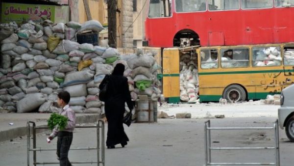 استخدام الحافلات لتجنب رصاص القناصين في شوارع مدينة حلب/أ.ف.ب