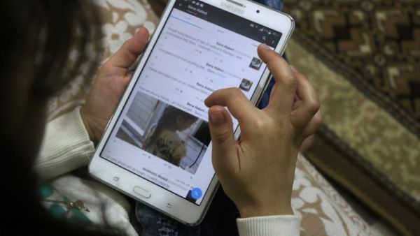 Young Aleppo reporter Bana al-Abed checks her Twitter account (Thaer Mohammed/AFP)