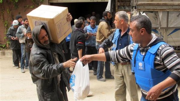 Displaced people from the Yarmouk Palestinian refugee camp queuing to receive aid from UNRWA in Yalda, south of the Syrian capital, Damascus in 2015. (AFP/File)