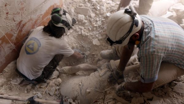 Syrian civil defence volunteers pull a body from under the rubble following a reported attack by Syrian government forces on May 27, 2016, in the Tariq al-Bab neighbourhood in the northern city of Aleppo. (AFP/Thaer Mohammed)