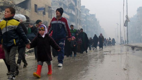 Syrian residents, fleeing violence in the restive Bustan al-Qasr neighborhood, arrive in Aleppo's Fardos neighborhood on December 13, 2016. (AFP/Stringer)
