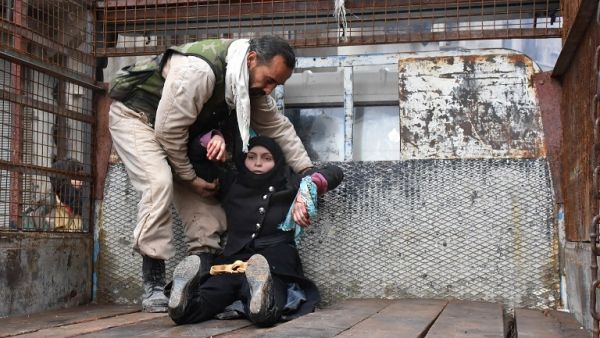 A wounded Syrian woman from the al-Sukari neighborhood is helped onto the back of a truck as she flees during the ongoing government forces military operation to retake remaining rebel-held areas in Aleppo on December 14, 2016. (AFP/George Ourfalian)