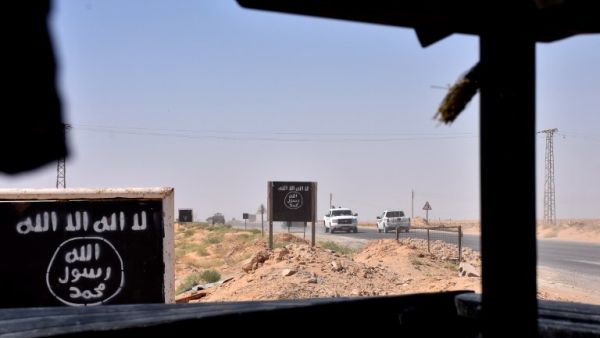 Billboards show the logo of the Islamic State (IS) group in the northern countryside of Deir Ezzor, where Syrian pro-government forces are holding a position on September 9, 2017 (George Ourfalian/AFP)
