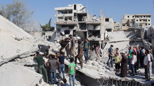 Syrian residents and members of the Syrian Civil Defence, also known as White Helmets, search for victims amid the rubble of a building following a reported overnight air strike in the rebel-held town of Armanaz, in Idlib province near the Turkish border, on September 30, 2017 (Omar Haj Kadour/AFP)