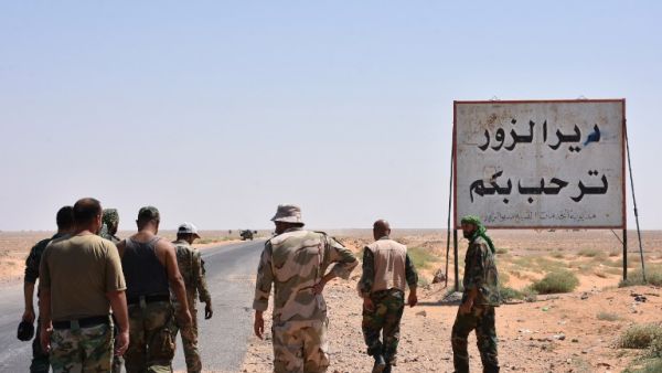 Members of the Syrian government forces stand on the entrance to Deir Ezzor city on September 3, 2017 (AFP)