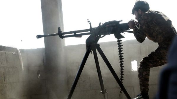 A member of the Kurdish People's Protection Units (YPG) fires a machine gun in the Syrian city of Raqa's eastern al-Sinaa district, on June 21, 2017, during an offensive by US-backed fighters to retake the Islamic State (IS) group bastion. (Delil Souleiman/AFP)
