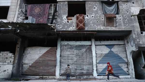 Syrian children play next to a destroyed buidling in the rebel-held town of Douma, on the eastern outskirts of the capital Damascus, on January 9, 2017. (AFP/Abd Doumany)