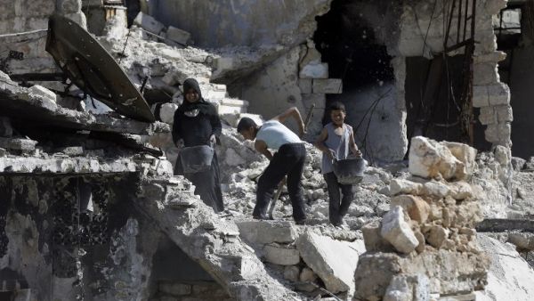 A Syrian family cleans the rubble from their destroyed house in Karm al-Jabal neighbourhood in the Northern Syrian city of Aleppo on March 9, 2017. (AFP/Joseph Eid)
