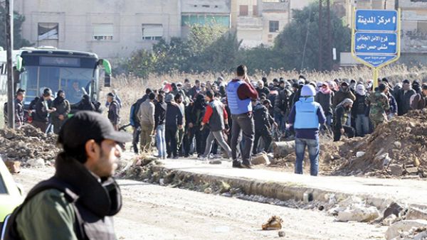Syrian government forces stand guard as civilians and rebels began evacuating the district of al-Waer in the city of Homs. (AFP/Louai Beshara)
