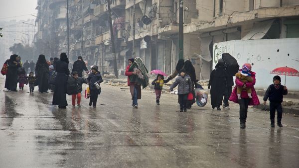 Under the hail of bullets, women and children hurry to leave one of the areas in south Damascus fought over by regimes forces and opposition groups, (AFP/ File Photo) 
