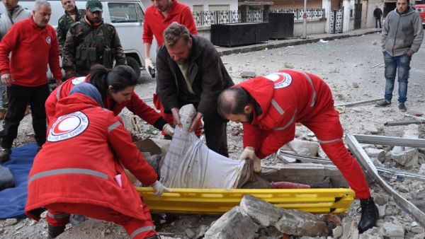 Syrian Red Crescent personnel evacuate the body of a man following a reported mortar strike by rebel fighters in a government-held part of the Syrian city of Homs, on February 10, 2017. (AFP/Stringer)