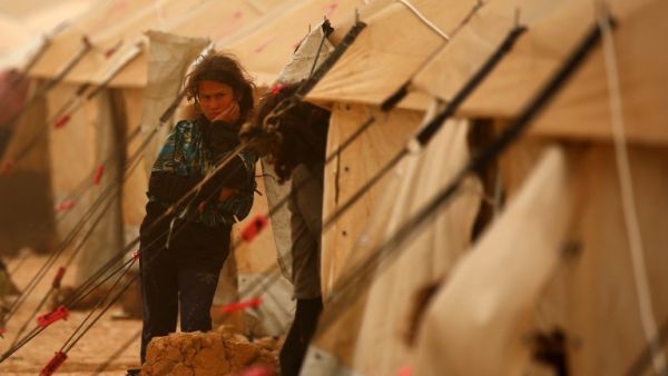 A displaced Syrian girls looks on during a sand storm at the al-Mabrouka camp in the village of Ras al-Ain on the Syria-Turkey border, where many Syrians who fled from territory held by the Islamic State (IS) group in Deir Ezzor and Raqa are taking shelter on April 23, 2017. (AFP/Delil Souleiman)