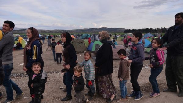 Syrian and Iraqi refugees wait to receive food at the Greek-Macedonian border near the village of Idomeni on February 27 , 2016. (AFP/Louisa Gouliamaki)