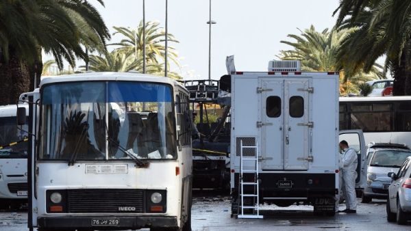 Tunisian police continue to investigate the wreckage of the bombed bus in Tunis, Tunisia. (AFP/Fethi Belaid)