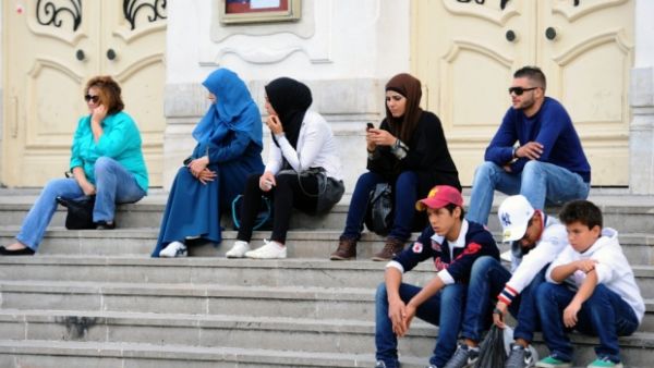 Young Tunisians sitting on the steps outside Habib Bourguiba Avenue in Tunis. (AFP/file)
