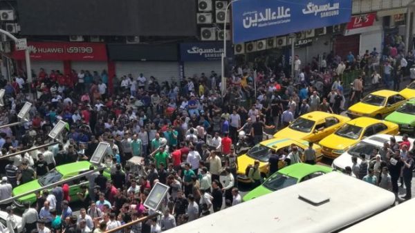 Iranian protesters outside a mobile phone shop in Tehran on 25 June 2018. (AFP/ File)