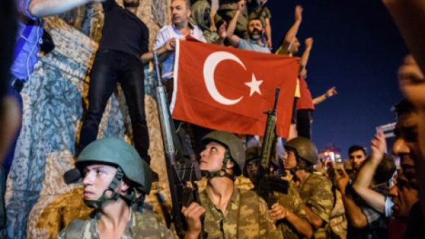 Turkish solders stay with weapons next to protesters in Istanbul on July 16, 2016. (AFP/Ozan Kose)