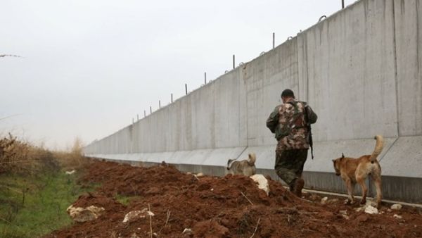  A Kurdish  fighter walks near a wall along the Syria-Turkey border at Ras al-Ain on February 2, 2016. (AFP / Delil Souleiman)