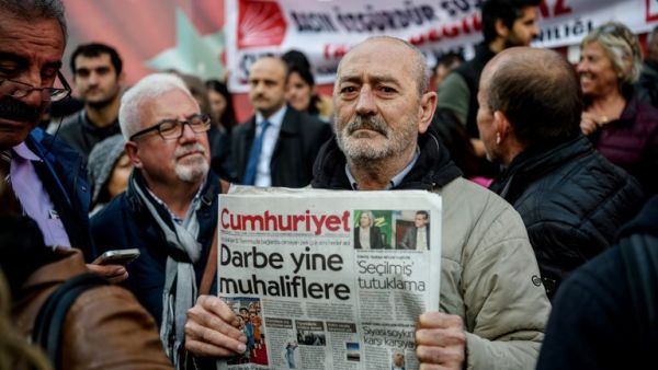 A protester holds a copy of Cumhuriyet newspaper during a protest in front of the opposition newspaper in Istanbul on October 31, 2016 after a police operation at the daily's headquarters. (AFP/Ozan Kose)