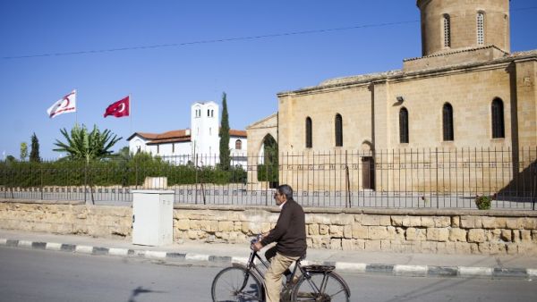 A man bicycles past the Greek Orthodox church of Saint Mamas in the town of Morphou in the self-proclaimed Turkish Republic of Northern Cyprus (TRNC) on November 2, 2016. (AFP/Florian Choblet)