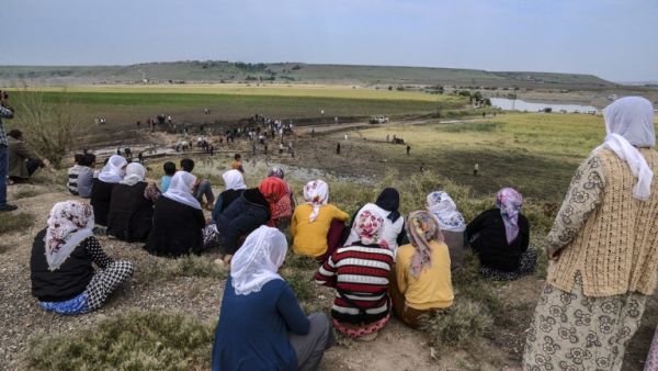 Women look at a huge crater after a powerful blast on May 13, 2016 in the area of Sarikamis on the outskirts of the majority Kurdish city of Diyarbakir. (AFP/Ilyas Akengin)