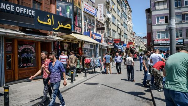 Syrian and Turkish people walk in a street next to shops with Arabic signs on July 4 ,2016 in Fatih neighborhood in Istanbul. (AFP/Ozan Kose)