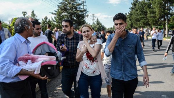 An injured woman, next to a man carrying her baby, walks near the site where a bomb explosed on May 10, 2016 in Diyarbakir. Three people were killed and 22 wounded in the attack. (AFP/Ilyas Akengen) An injured woman, next to a man carrying her baby, walks near the site where a bomb explosed on May 10, 2016 in Diyarbakir. Three people were killed and 22 wounded in the attack. (AFP/Ilyas Akengen)