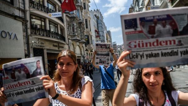 Demonstrators hold copies of pro-Kurdish newspaper Ozgur Gundem as they a protest against the arrest of three press freedom activists on June 25, 2016 in Istanbul (AFP Photo/Ozan Kose)