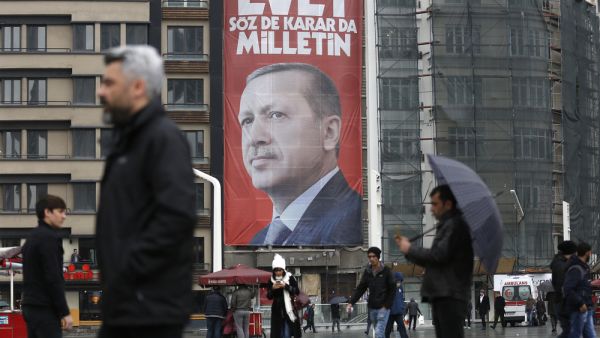 ISTANBUL, TURKEY, 13 MARCH 2017 People walk in front of a picture of Turkish President Recep Tayyip Erdogan. 